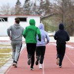 Skolēni skrien sporta laukumā