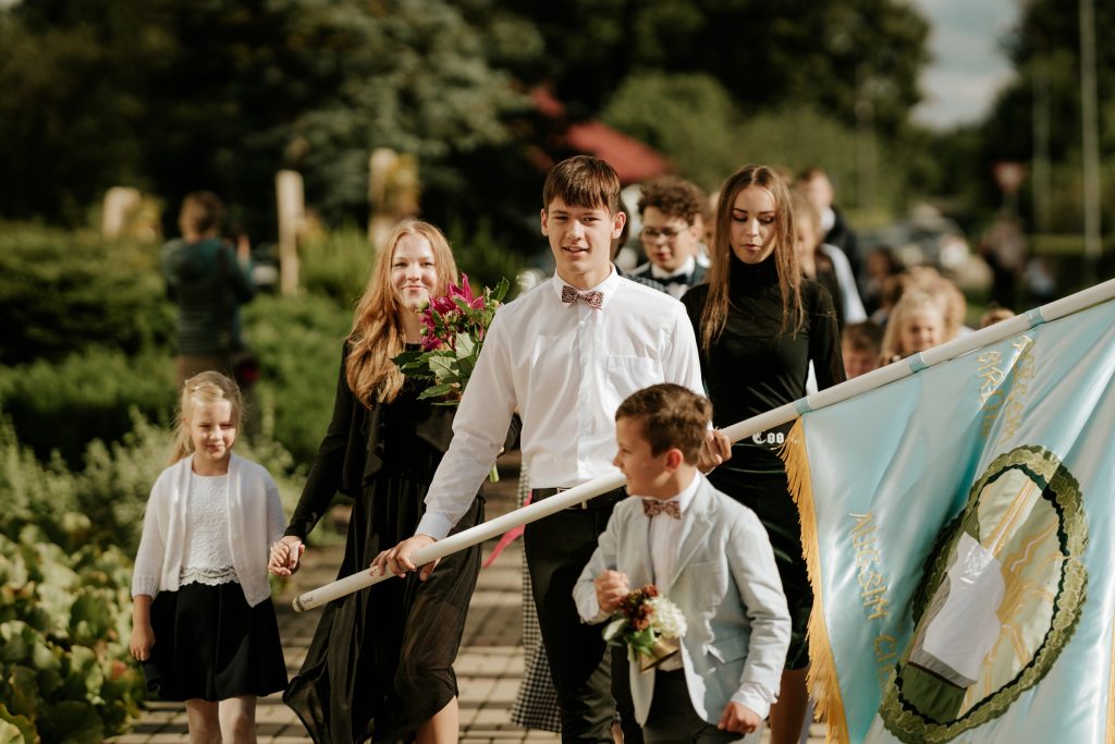 Skolēni Zinību dienā nes skolas karogu