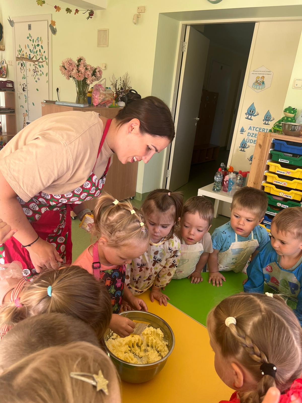 Skolotāja un bērni cep cepumus